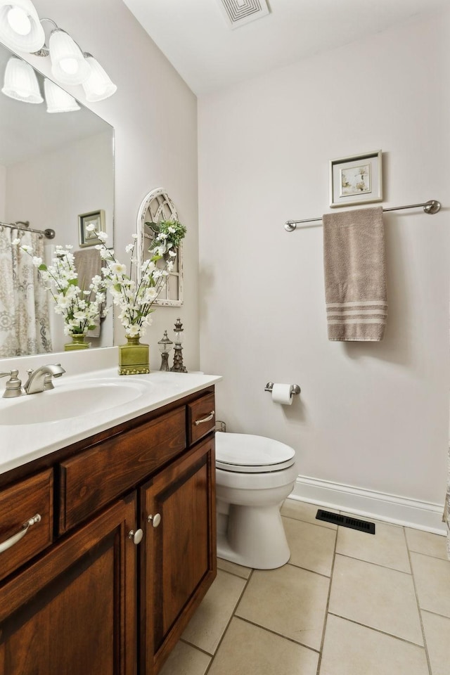 bathroom featuring vanity, tile patterned floors, and toilet