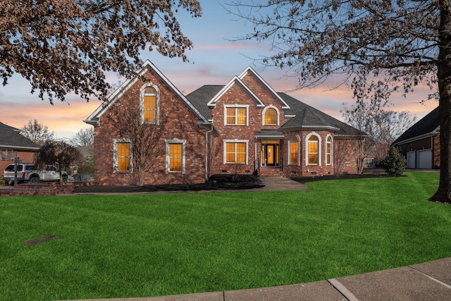 front facade with a garage and a yard