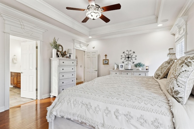 bedroom with a raised ceiling, crown molding, ceiling fan, and light wood-type flooring