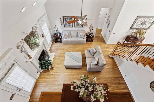 living room featuring a high ceiling, hardwood / wood-style flooring, and ceiling fan