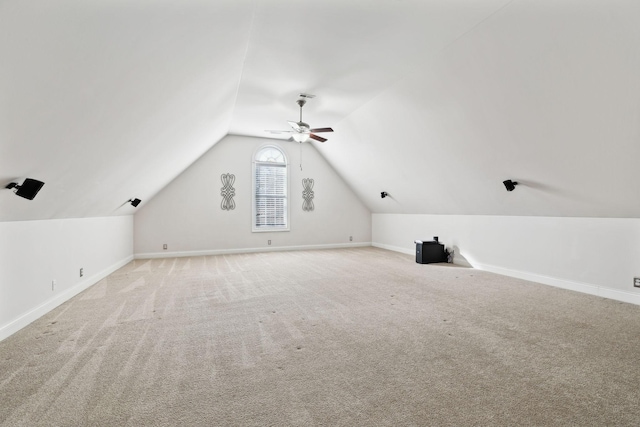 additional living space featuring vaulted ceiling, light carpet, and ceiling fan