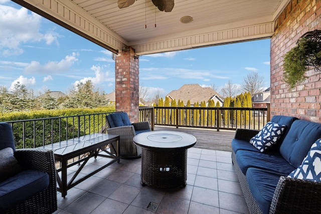 view of patio / terrace with ceiling fan and an outdoor living space with a fire pit