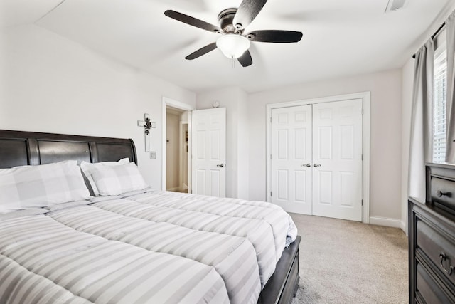 bedroom with lofted ceiling, light colored carpet, a closet, and ceiling fan