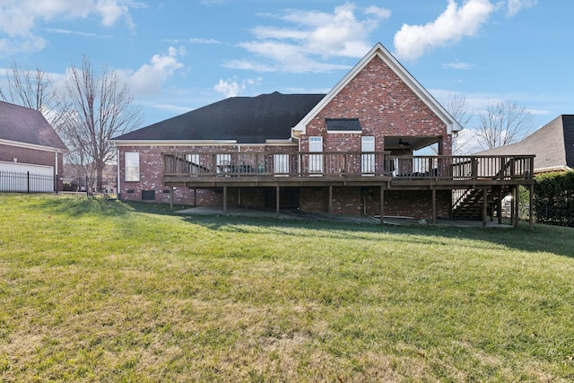 rear view of house featuring a wooden deck and a lawn