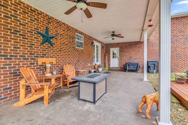 view of patio with ceiling fan and an outdoor fire pit