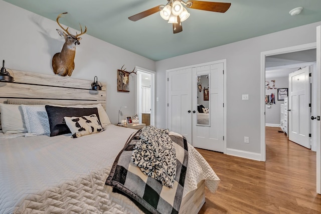 bedroom with ceiling fan, light hardwood / wood-style floors, and a closet