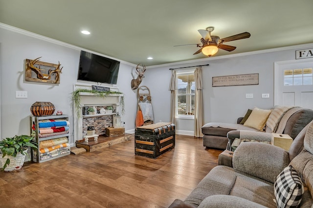 living room featuring wood-type flooring, a healthy amount of sunlight, ceiling fan, and ornamental molding