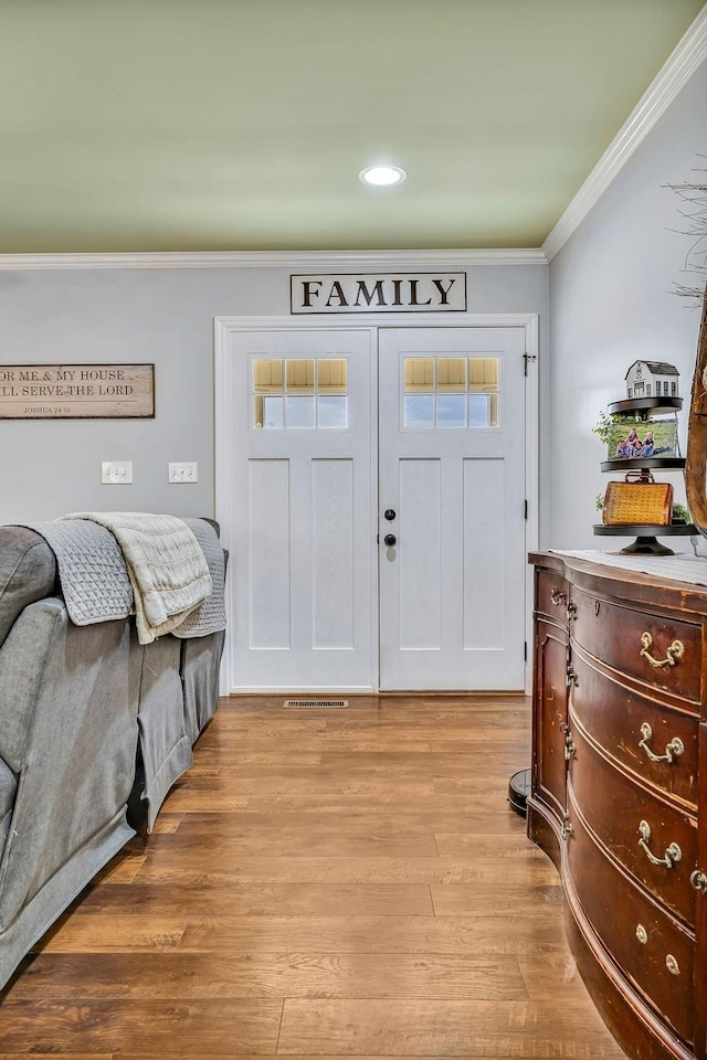 foyer entrance featuring ornamental molding and light hardwood / wood-style floors