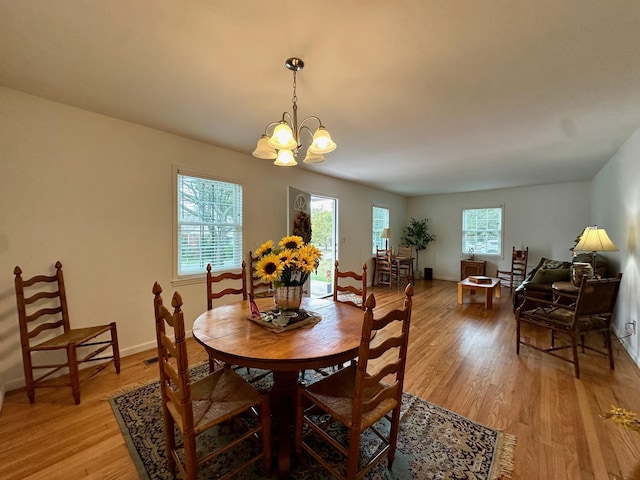 dining space with a notable chandelier and light wood-type flooring