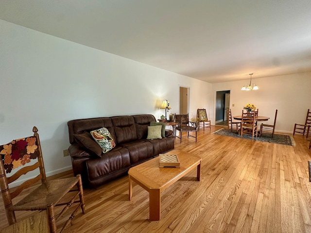 living room featuring a chandelier and light wood-type flooring