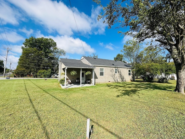 back of property featuring a patio and a lawn