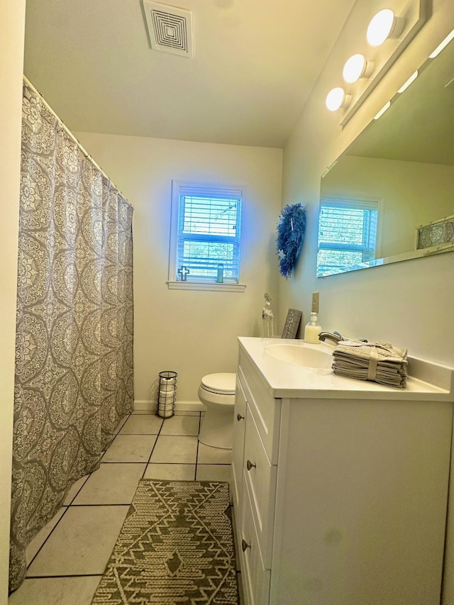 bathroom featuring tile patterned flooring, vanity, plenty of natural light, and toilet