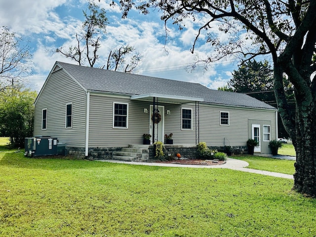 view of front facade with a front yard and central AC unit