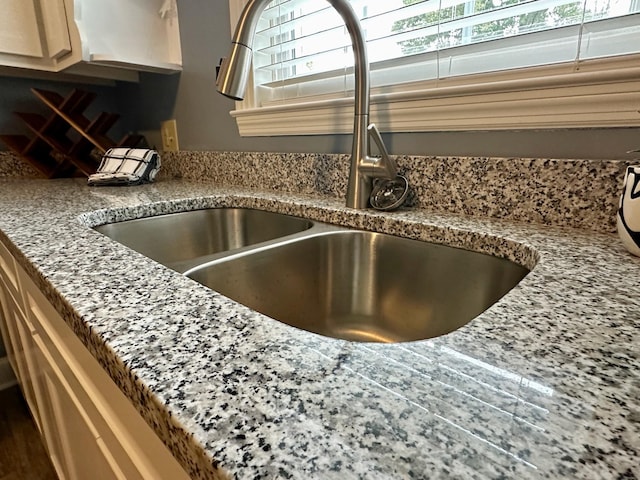 interior details featuring stone countertops and sink