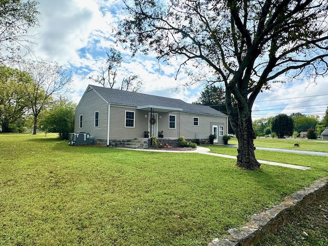 ranch-style house featuring a front yard and central AC unit