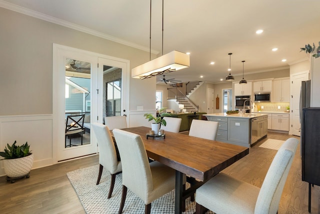 dining area featuring ornamental molding, ceiling fan, and light wood-type flooring