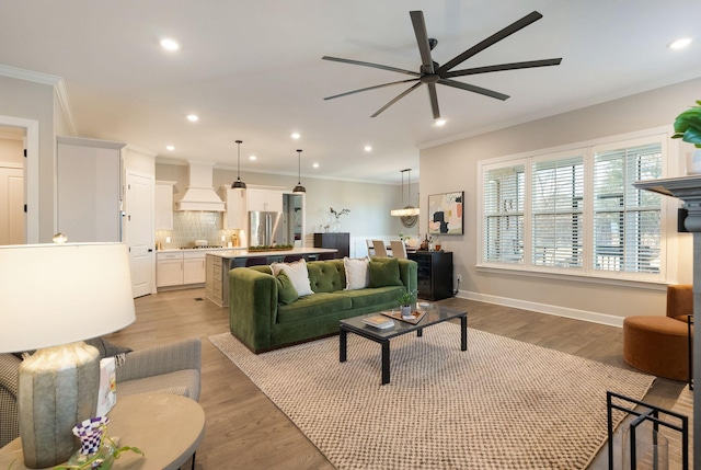 living room with ornamental molding, ceiling fan, and light hardwood / wood-style floors