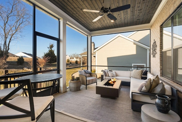 sunroom featuring wood ceiling and ceiling fan