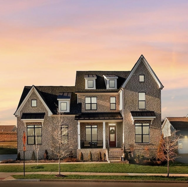 view of front of home with a lawn and covered porch