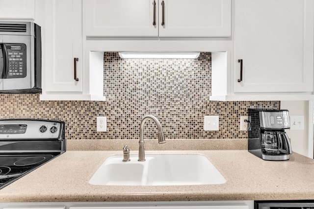 kitchen featuring white cabinetry, stainless steel appliances, sink, and tasteful backsplash