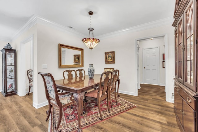 dining room featuring crown molding and hardwood / wood-style floors