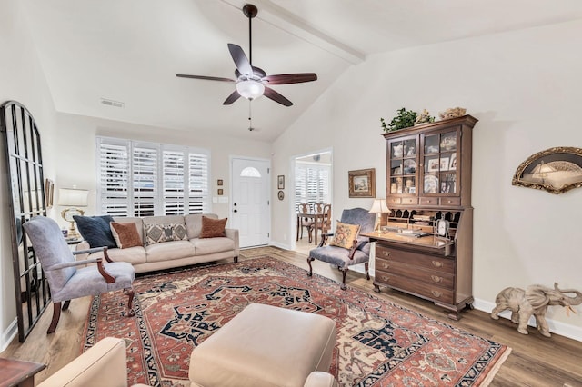 living room with wood-type flooring, lofted ceiling with beams, and ceiling fan