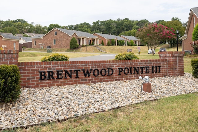 community / neighborhood sign with a yard