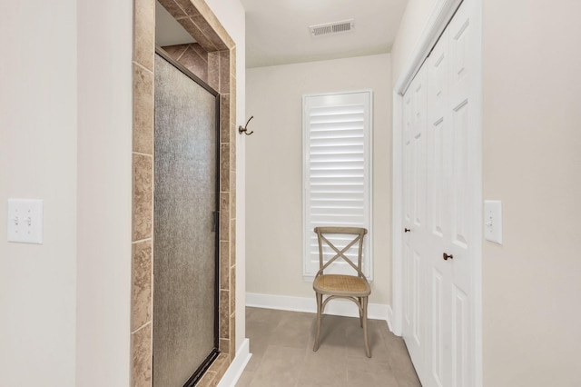 bathroom with tile patterned flooring and a shower with door