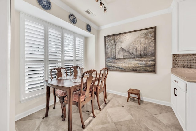 dining room with track lighting and ornamental molding