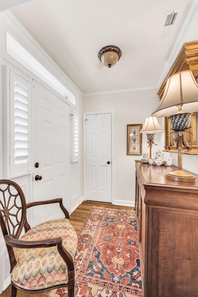 foyer entrance featuring ornamental molding and dark wood-type flooring