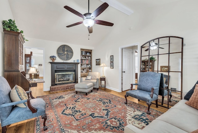 living room with a brick fireplace, hardwood / wood-style floors, built in features, and ceiling fan