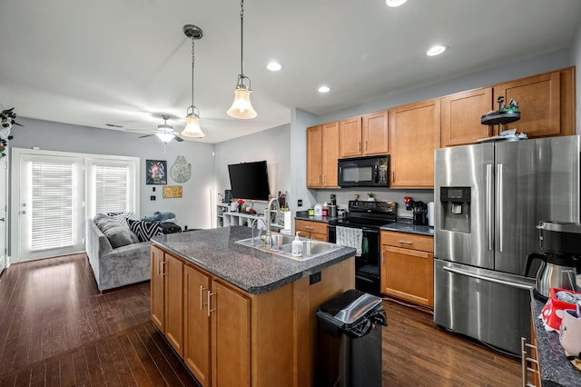 kitchen with dark hardwood / wood-style floors, pendant lighting, an island with sink, sink, and black appliances