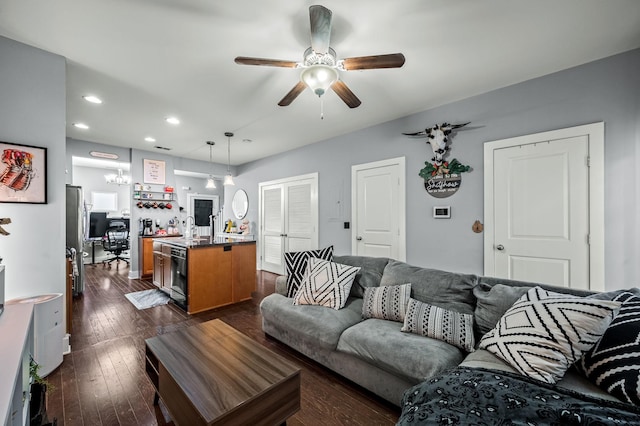 living room featuring ceiling fan and dark hardwood / wood-style flooring