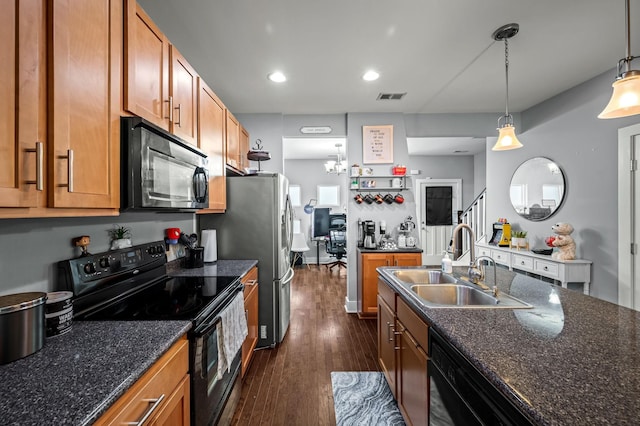 kitchen with decorative light fixtures, sink, dark stone countertops, black appliances, and dark wood-type flooring