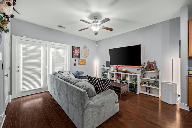 living room featuring dark wood-type flooring and ceiling fan