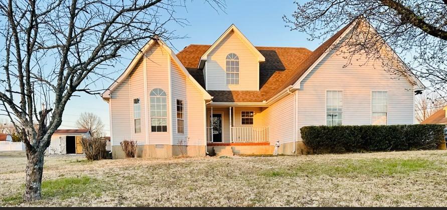 view of front of property with a porch, a front yard, and crawl space