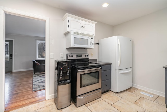 kitchen with white cabinetry, white appliances, and light tile patterned flooring