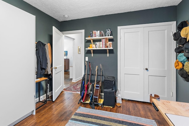 interior space featuring a textured ceiling and dark hardwood / wood-style flooring