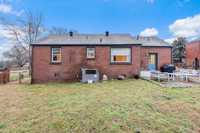 rear view of house with cooling unit and a lawn