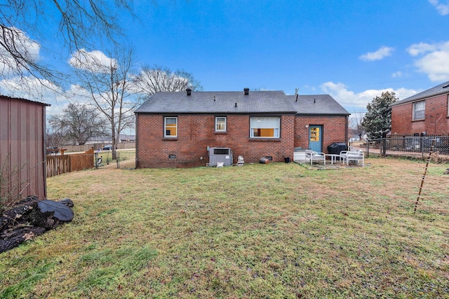 rear view of house featuring central AC unit and a yard