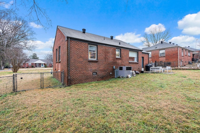 rear view of house with central AC and a lawn