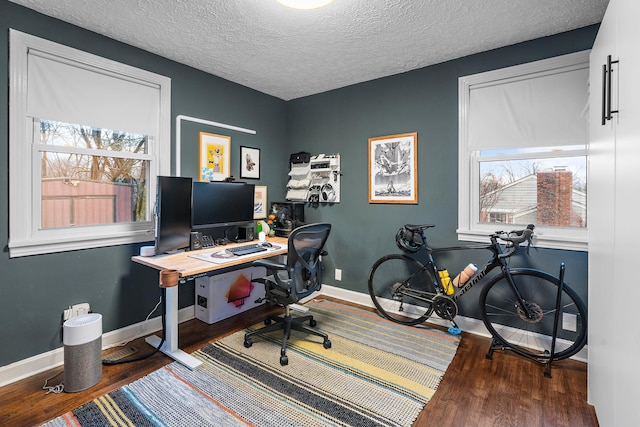 office area with dark hardwood / wood-style flooring and a textured ceiling