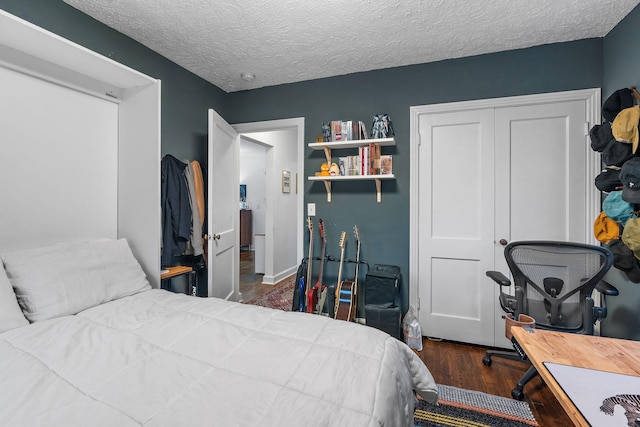 bedroom featuring dark wood-type flooring, a closet, and a textured ceiling