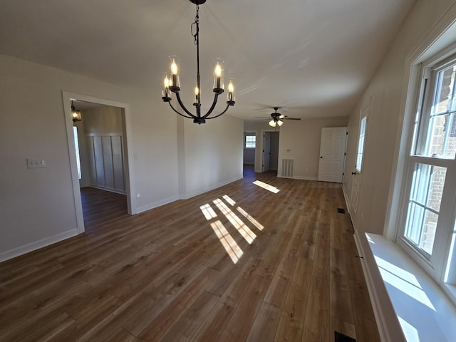 unfurnished dining area featuring dark hardwood / wood-style floors and ceiling fan with notable chandelier