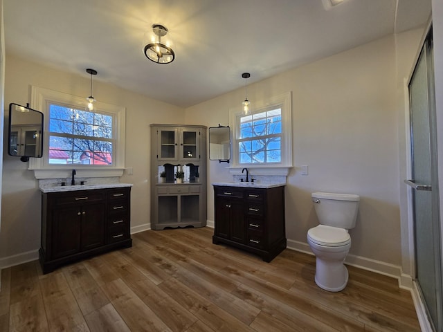 interior space featuring dark brown cabinetry, decorative light fixtures, and hardwood / wood-style flooring