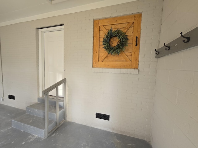 interior space featuring brick wall and concrete floors