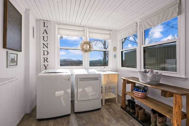 laundry room with dark hardwood / wood-style flooring, wooden ceiling, and washing machine and clothes dryer