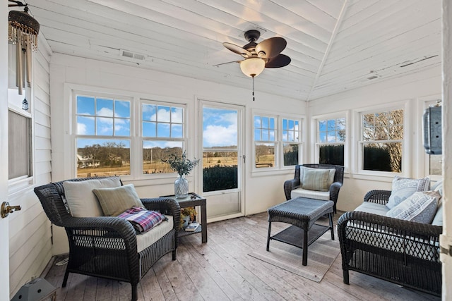 sunroom featuring lofted ceiling, wooden ceiling, and ceiling fan