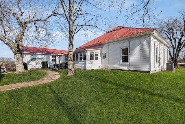 back of property featuring a lawn and central air condition unit