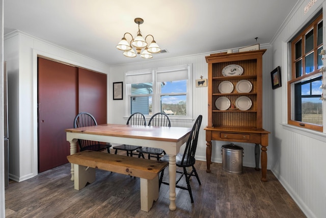 dining room with an inviting chandelier, dark hardwood / wood-style flooring, and crown molding